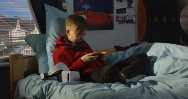 Jongen met zijn smartphone thuis — Stockvideo