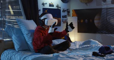 VR kulaklık ve dış iskelet eldiven ile oynayan çocuk