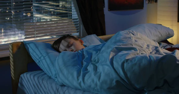 Мальчик спит в своей постели — стоковое фото