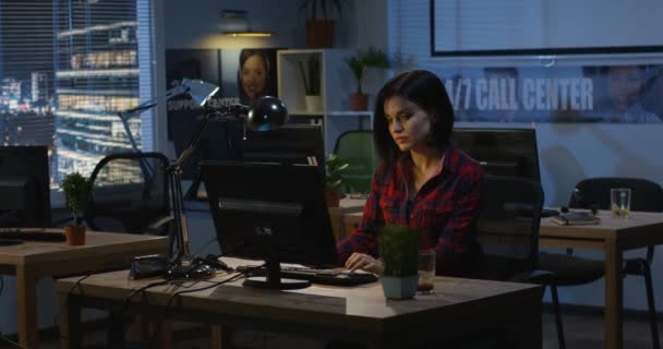Młoda kobieta pracuje w nocy w biurze — Wideo stockowe