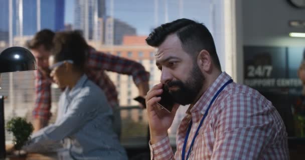 Hombre hablando por teléfono en una oficina — Vídeos de Stock