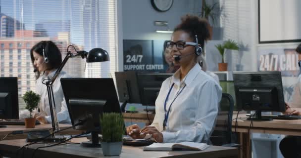 Mujer joven trabajando en su escritorio — Vídeos de Stock