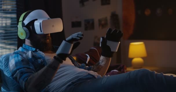 Homme portant un casque VR au lit — Video