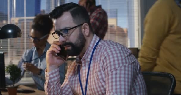 Мужчина разговаривает с телефоном в офисе — стоковое видео