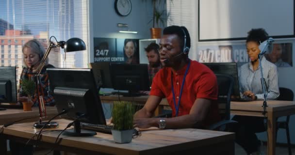 Young man working at a support center — Stock Video