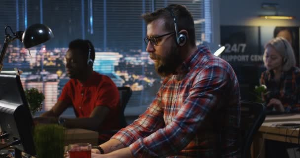 Trabajador del centro de llamadas poniendo auriculares — Vídeos de Stock