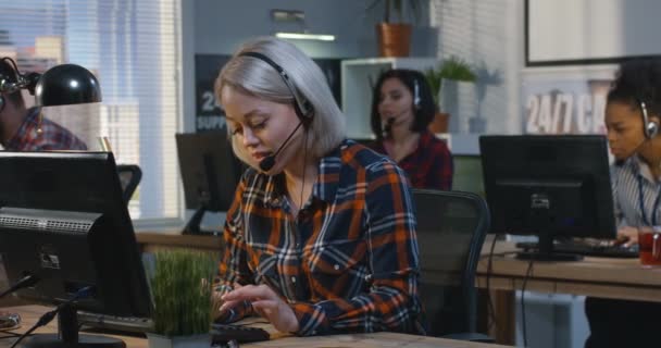 Vrouw die werkt aan zijn Bureau in een callcenter — Stockvideo