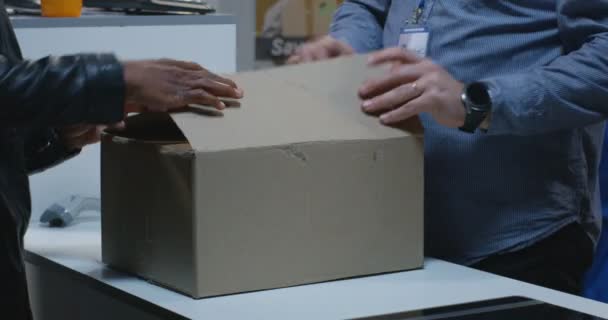 Bir teslimat merkezinde bir paket posta adam — Stok video