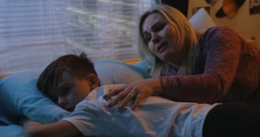 Anne üzgün çocuğu teselli ediyor.