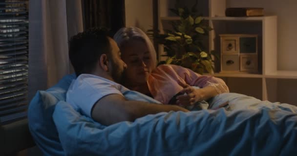 Ζευγάρι χρησιμοποιώντας το smartphone στο κρεβάτι — Αρχείο Βίντεο