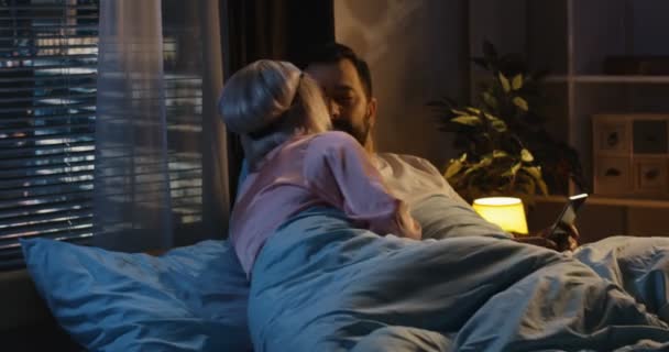 Пара в постели перед сном — стоковое видео