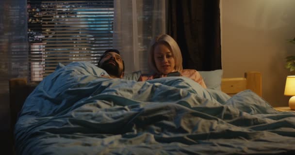 Paar gebruikend smartphone in bed — Stockvideo