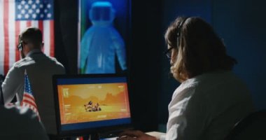 Masalarında çalışan Mars görev teknisyenleri