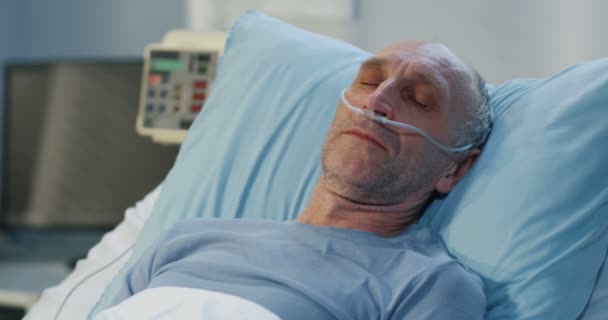 Человек лежит в больничной койке — стоковое видео