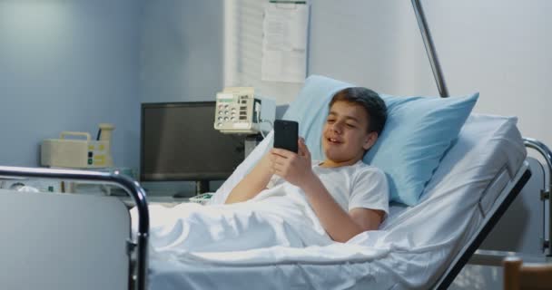 Mladistvej pacient používající mobil v nemocnici — Stock video