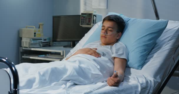 Teenager boy lying in hospital — Stock Video