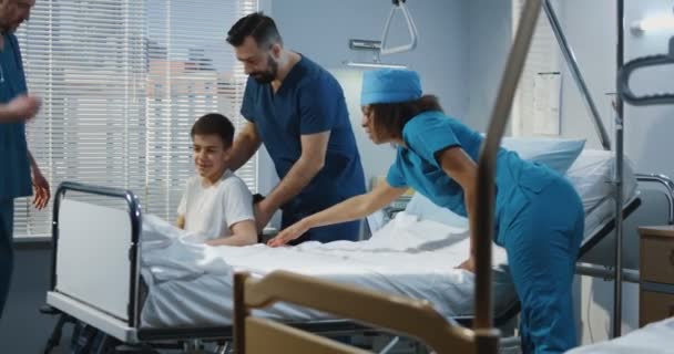 Медбрат и врач поднимают пациента в постель — стоковое видео