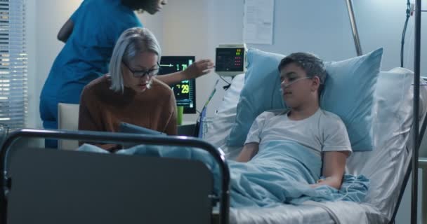 Mutter liest kranken Sohn vor — Stockvideo