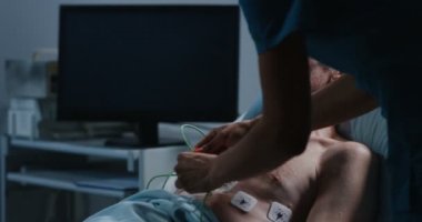 Doktorlar kalp hızını kontrol etmek için hastaya kablo yerleştirerek