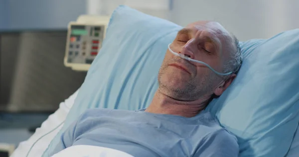 Чоловік лежить на ліжку лікарні — стокове фото