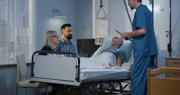 家族の間で病院に横たわっている男性患者 — ストック写真