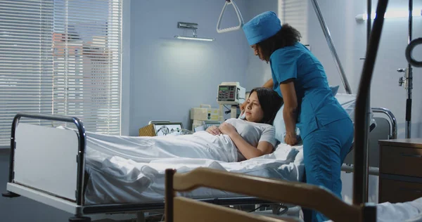 Male nurse and doctor lifting patient into his bed