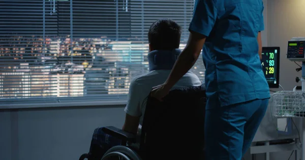 휠체어환자를 창문으로 밀어내는 간호사 — 스톡 사진