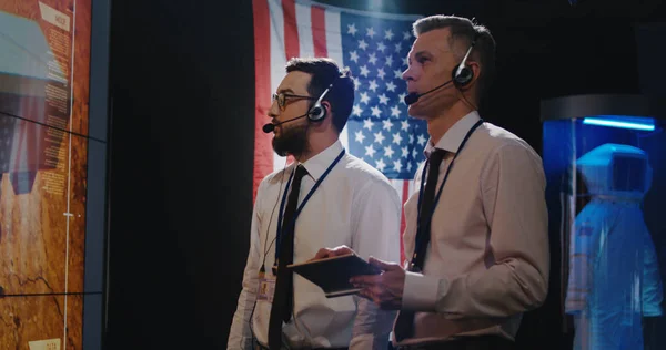 Two technicians watching screen in control room