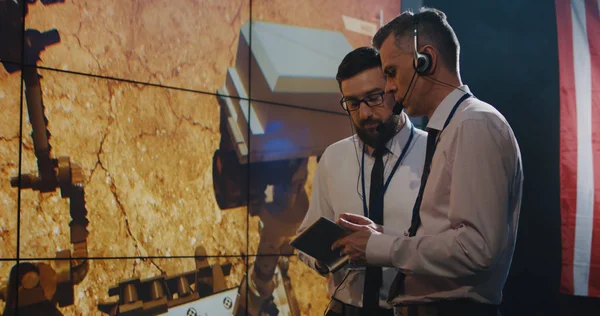 Dois técnicos assistindo tela na sala de controle — Fotografia de Stock