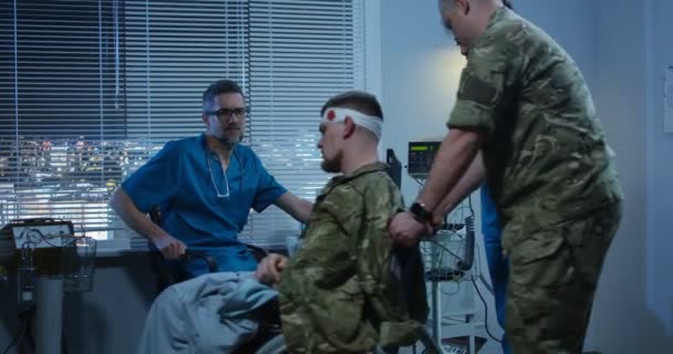 Soldat sittande i rullstol bland läkare och sjuksköterska — Stockvideo
