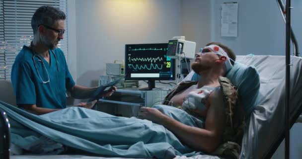 Doktor yaralı hastaya röntgen gösteriyor — Stok video