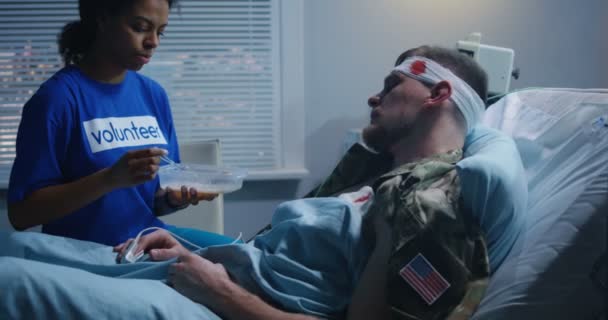 Verpleegster voeden geblesseerd soldaat in ziekenhuis bed — Stockvideo