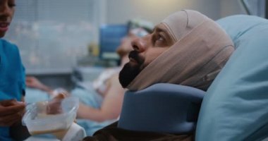 Yaralı askerleri hastane yatağında besleyen hemşire