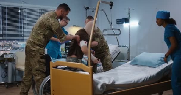 Tentara yang terluka di rumah sakit antara dokter dan perawat — Stok Video