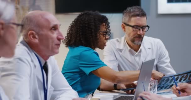 Médicos discutiendo resultado de resonancia magnética — Vídeo de stock