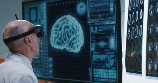Médico examinando varredura cerebral com fone de ouvido VR — Vídeo de Stock