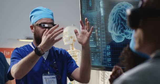 Médico explicando com fone de ouvido VR — Vídeo de Stock