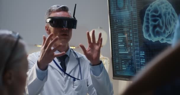 Médico explicando com fone de ouvido VR — Vídeo de Stock