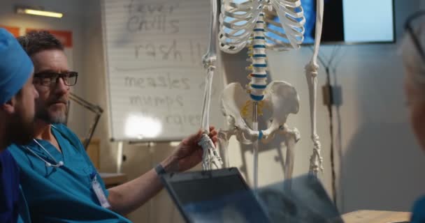 Врачи, изучающие рентген шейного отдела позвоночника — стоковое видео