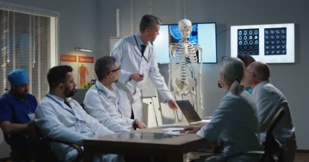 Doutor explicando diagnóstico para seus colegas — Vídeo de Stock