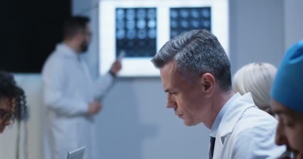 Medici che osservano il loro collega che spiega la diagnosi — Video Stock