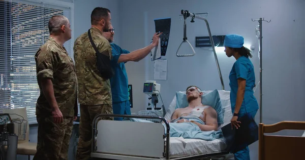 Ο γιατρός δείχνει ακτίνες χ σε επισκέπτες στρατιώτες στο νοσοκομείο. — Φωτογραφία Αρχείου