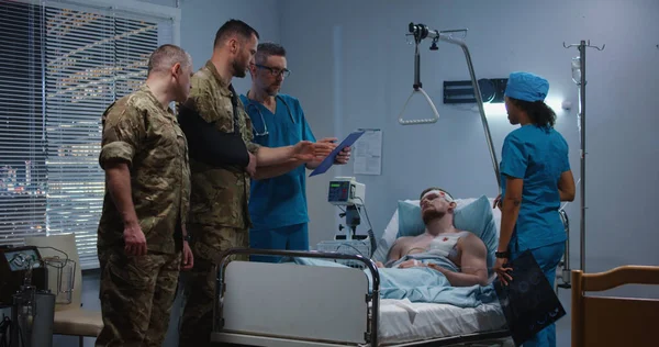 Medico che mostra raggi X ai soldati visitatori in ospedale — Foto Stock