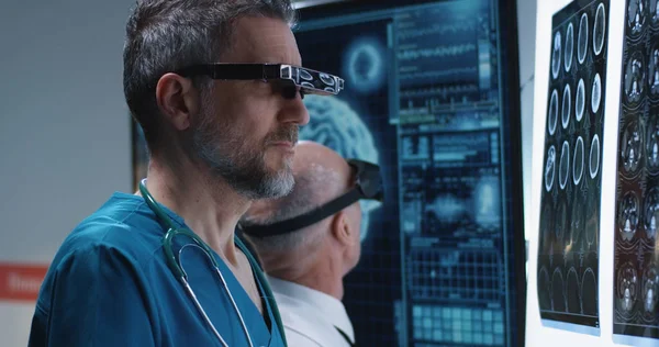 Médicos examinando a varredura cerebral com fone de ouvido VR — Fotografia de Stock