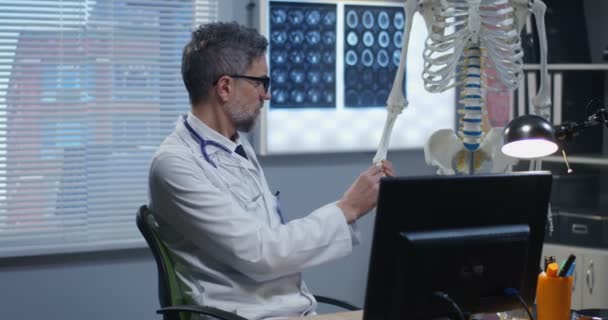 Médecin utilisant le modèle squelette pour analyser l'anatomie des mains — Video