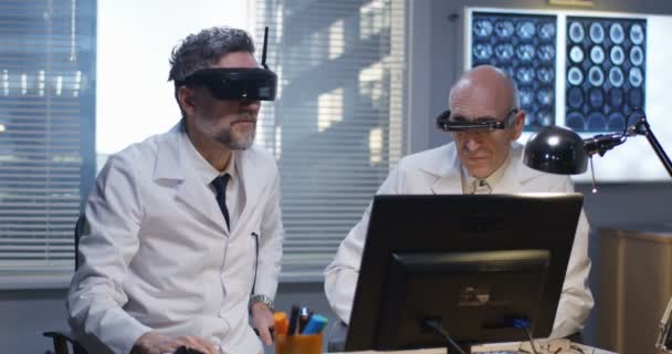 Лікарі дивляться екран за допомогою гарнітури віртуальної реальності — стокове відео