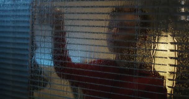 Niño viendo tormenta a través de la ventana — Vídeos de Stock