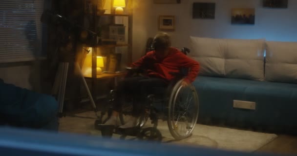 Wheelchaired chlapec sledování bouře z místnosti — Stock video