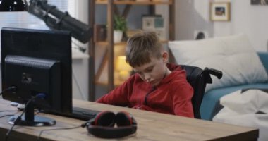 Wheelchaired boy using computer