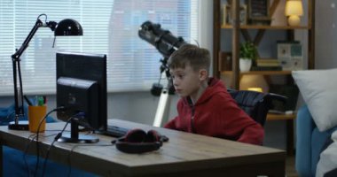 Wheelchaired boy using computer